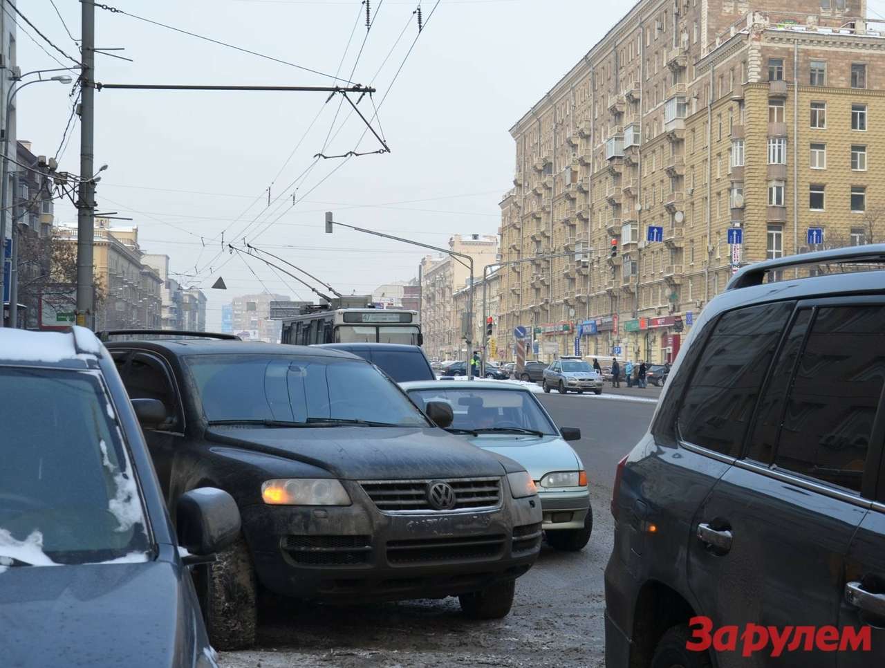 В три ряда припаркованы автомобили на Новослободской, но этого бедлама в упор не замечает экипаж ДПС, расположившийся на осевой (смотрите, его машина видна поодаль, в просвете между стоящими). Инспекторов не насторожило, что троллейбусы ползком, выгнув токоприемники раз за разом огибают эту кучу-малу.