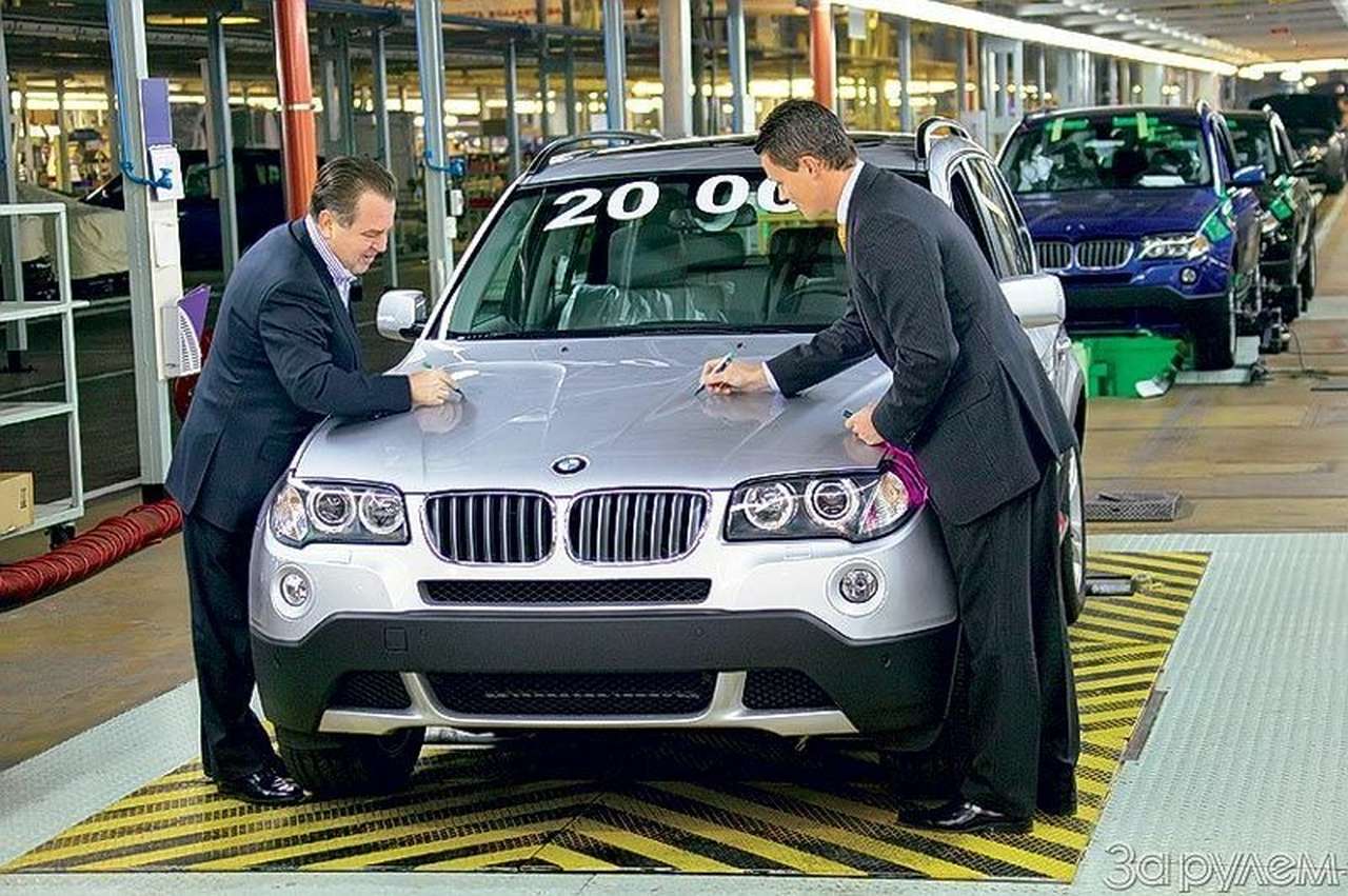 В. Щербаков и К. Кремер (справа) оставили автографы на капоте юбилейного Х3. Капот отправится в музей, а машина (с новой деталью) - к потребителю.