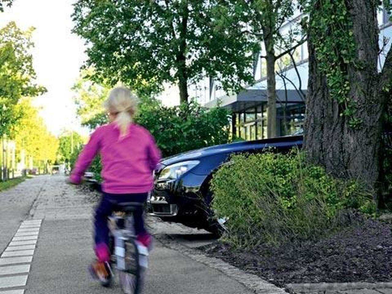 Новую «семерку» снабдили «боковым зрением»: дерево мешает водителю увидеть юную велосипедистку, но видеокамера передает ее изображение на монитор.