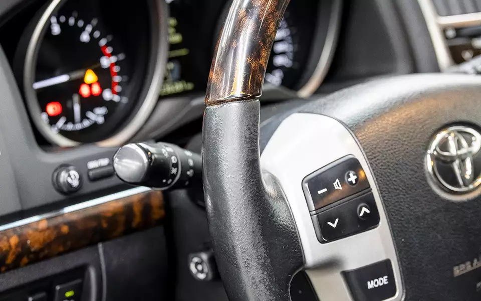 Кожаная часть оплетки руля рановато начинает поблескивать, но существенно ветшает со сглаживанием фактуры обычно лишь к 150–200 тысяч км. Лак на «деревянном» декоре обода тускнеет, а со временем «ламинат» может и протереться.