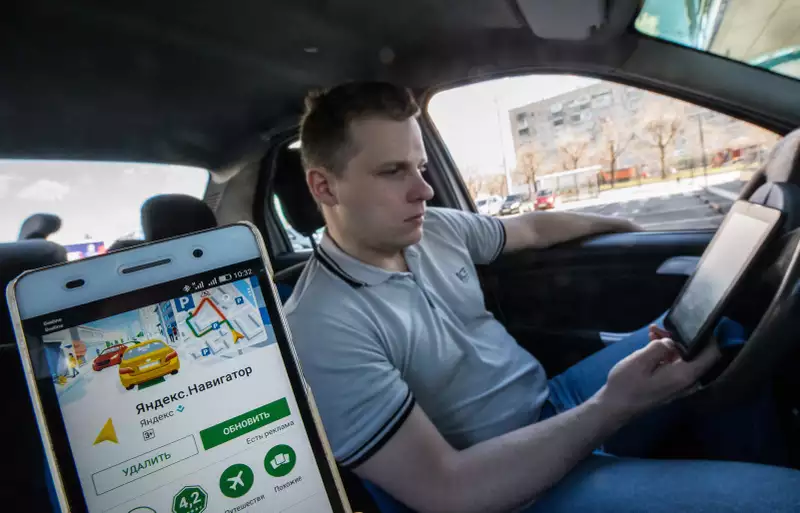 водитель такси смотрит в навигатор