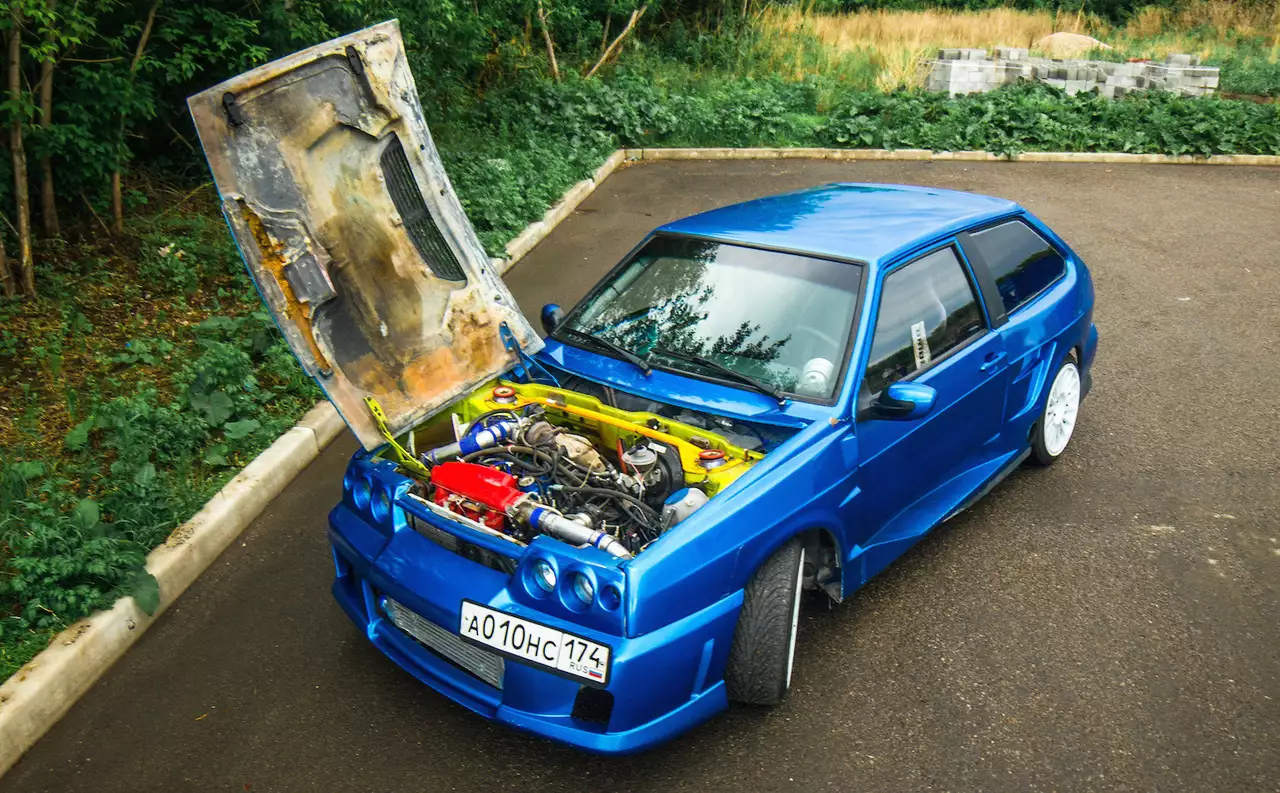 Максимальная скорость этого ВАЗ-2108 – около 270 км/ч. На таких скоростях подъемная сила создает реальную опасность открыть капот. Вот почему петли перенесли на 90 градусов, дополнив капот спортивными замками.