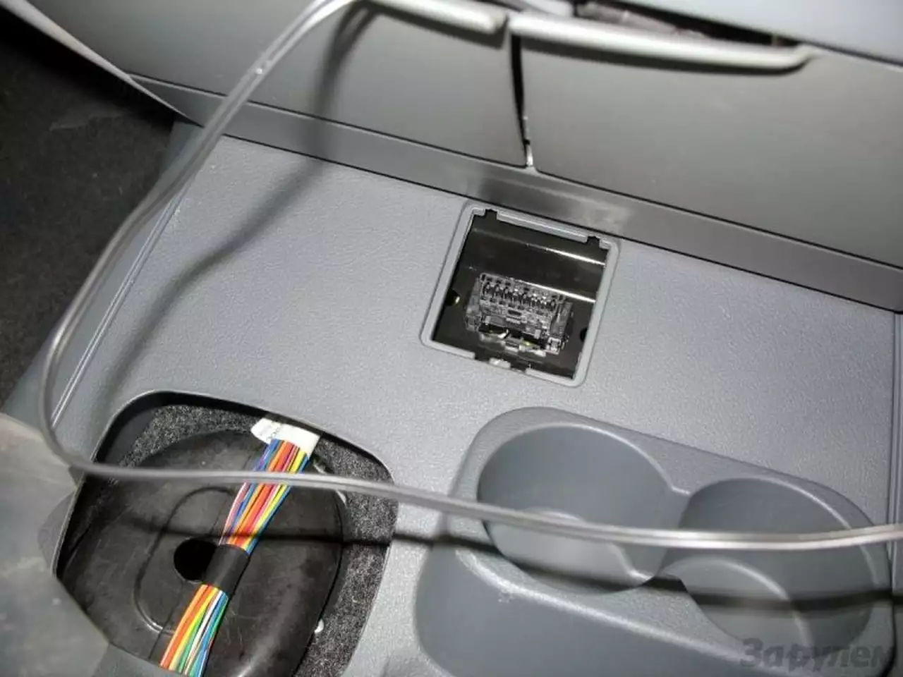 В новом тоннеле пола предусмотрено место под диагностический разъем. Напомним, ранее он болтался на проводах у ног водителя. Одновременно изжит еще один дефект – плохая фиксации чехла рычага КП. Нынче за счет стабильной толщины стенки (тоннель отливают сразу с отверстием, которое ранее вырезали) чехол держится гораздо лучше.