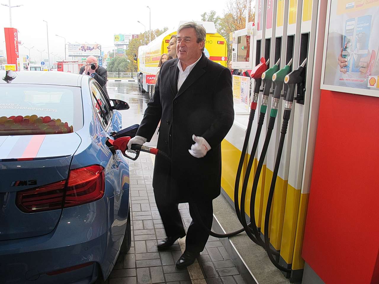 Вице-президент лично заправляет автомобиль Номер Один. Чуть позже он распишется на бочонке с символическим первым проданным галлоном бензина!