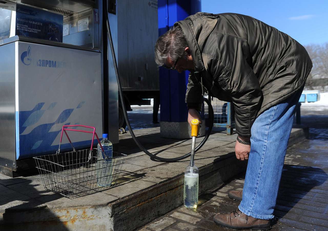 Сотрудник государственного экологического надзора во время взятия пробы бензина для проверки качества на одной из заправочных станций.