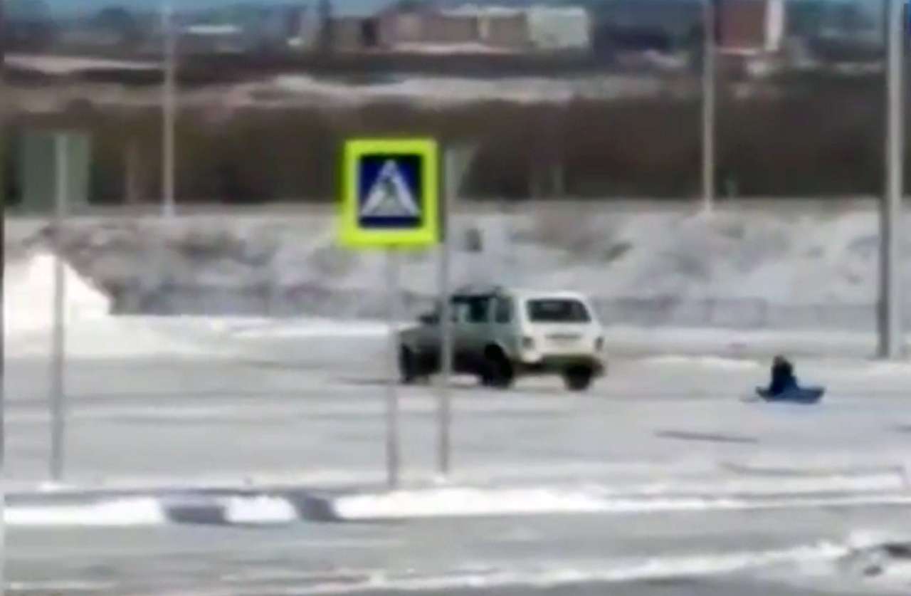 Пока мама в магазине: отец прокатил дочку на прицепленных к машине санках